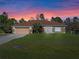 House exterior at sunset, featuring a brown roof and attached garage at 18433 Reynolds Pkwy, Orlando, FL 32833