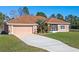 Single-story home with a brown roof, attached garage, and landscaped yard at 18433 Reynolds Pkwy, Orlando, FL 32833