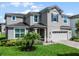 Two-story house with gray siding, three-car garage, and landscaping at 1873 Donahue Dr, Ocoee, FL 34761