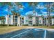 Exterior view of a two-story apartment building with lush landscaping and ample parking at 2230 Cascades Blvd # 207, Kissimmee, FL 34741