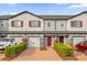 Two-story townhome with gray siding, red shutters, and a brick driveway at 232 Rustic Loop, Sanford, FL 32771