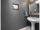 Clean bathroom with pedestal sink and dark gray walls at 252 Wimbledon Cir # 1702, Lake Mary, FL 32746