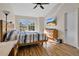 Main bedroom with wood floors, large windows, and TV at 2823 Boulder Falls Ct, Apopka, FL 32703