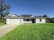 Newly constructed home with a white garage door and well-manicured lawn at 3 Fisher Loop Crse, Ocklawaha, FL 32179