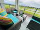 Lake view patio with wicker furniture and colorful pillows at 3151 Paradox Cir # 103, Kissimmee, FL 34746