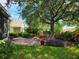 Landscaped backyard with brick patio, lush greenery, and a large shade tree at 370 Silver Maple Rd, Groveland, FL 34736