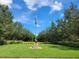 Landscaped area with American flag and monument at 370 Silver Maple Rd, Groveland, FL 34736