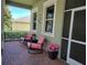 Relaxing front porch with pink rocking chairs and brick flooring at 370 Silver Maple Rd, Groveland, FL 34736