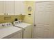 Bright laundry room with washer, dryer, and ample cabinet space at 370 Silver Maple Rd, Groveland, FL 34736