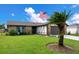 Ranch style home with stone accents, mature landscaping, and American flag at 4 Sea Hawk Dr, Ormond Beach, FL 32176