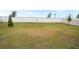 Large grassy backyard area with a white vinyl fence at 4398 Davos Dr, Clermont, FL 34711