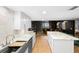 Open kitchen featuring a breakfast bar, marble countertops and backsplash, wood flooring, and stylish white cabinetry at 530 E Central Blvd # 603, Orlando, FL 32801