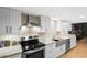 Modern kitchen featuring stainless steel appliances, a marble countertop, and white cabinets with hardwood flooring at 530 E Central Blvd # 603, Orlando, FL 32801