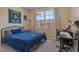 Bright bedroom with a queen-size bed, workspace, and large window at 5441 Leighton Ln, Oviedo, FL 32765