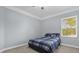 Cozy bedroom with a full-size bed and large window at 5590 Whispering Woods Pt, Sanford, FL 32771