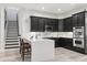 Modern kitchen with island, dark cabinetry, and stainless steel appliances at 5590 Whispering Woods Pt, Sanford, FL 32771