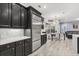 Modern kitchen with dark cabinetry, stainless steel appliances, and quartz countertops at 5590 Whispering Woods Pt, Sanford, FL 32771