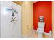 Small bathroom with toilet, safe, and red accent wall at 5737 Masters Blvd, Orlando, FL 32819