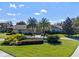 Charming home featuring a manicured lawn, lush landscaping, and elegant palm trees at 5737 Masters Blvd, Orlando, FL 32819