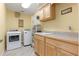 Laundry room with modern washer and dryer, utility sink, and ample cabinet space at 5737 Masters Blvd, Orlando, FL 32819