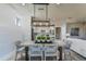 Bright dining room features a rustic table with woven chairs, modern lighting, and a view into the kitchen at 6375 Dew Drop Loop, St Cloud, FL 34771