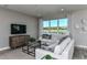 Living room features white sofas, a wood media console, and large windows with a lake view at 6375 Dew Drop Loop, St Cloud, FL 34771