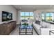 Living room features white sofas, a wood media console, and large windows with a lake view at 6375 Dew Drop Loop, St Cloud, FL 34771