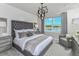 Spacious main bedroom with a tufted headboard, large window, and modern chandelier at 6375 Dew Drop Loop, St Cloud, FL 34771