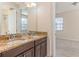 Bathroom with granite double vanity and dark wood cabinets at 8146 Prestbury Dr, Orlando, FL 32832