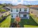 Two-story house back with a covered patio, fenced yard, and manicured lawn at 8146 Prestbury Dr, Orlando, FL 32832