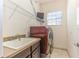 Bright laundry room with washer, dryer, sink, and ample shelving at 8146 Prestbury Dr, Orlando, FL 32832