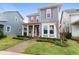 Two-story house with taupe and blue siding, pink shutters, and a covered porch at 8226 Nemours Pkwy, Orlando, FL 32827