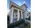 Covered front porch with white columns and a pink door at 8226 Nemours Pkwy, Orlando, FL 32827