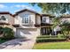 Two-story house with a light-colored facade, brown roof, and manicured landscaping at 8312 Via Rosa, Orlando, FL 32836