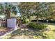 Landscaped backyard with storage shed, lush lawn and large trees at 846 Leopard Trl, Winter Springs, FL 32708