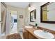 Bathroom with double vanity, wood cabinets, and access to screened porch at 846 Leopard Trl, Winter Springs, FL 32708