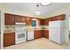 Kitchen features wood cabinets, white appliances, and tile floors at 846 Leopard Trl, Winter Springs, FL 32708