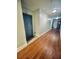 Hallway with wood floors leading to unit 163, showing the blue front door at 860 N Orange Ave # 163, Orlando, FL 32801