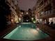 Sparkling pool at night, surrounded by residential buildings and lush tropical greenery at 860 N Orange Ave # 163, Orlando, FL 32801