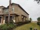 Side view of townhome showcasing its light brown exterior and landscaping at 8973 Azalea Sands Ln # 8973, Davenport, FL 33896