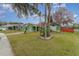 Green house with palm trees and a landscaped yard at 926 Freshmeadow Ct, Apopka, FL 32703