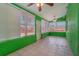 Sunroom with tile flooring, green walls, and two ceiling fans at 926 Freshmeadow Ct, Apopka, FL 32703