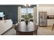 Modern dining room with dark wood table and view to kitchen at 10136 Huntingnet Way, Leesburg, FL 34748