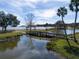 Scenic park with wooden bridge over calm lake water at 10136 Huntingnet Way, Leesburg, FL 34748