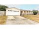 Ranch-style home with a white garage door and a small front yard at 102 Carriage Hill Dr, Casselberry, FL 32707