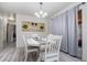 Bright dining room features a rustic table with four chairs and light gray curtains at 1074 Gerona Ave, Deltona, FL 32725