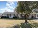 Ranch-style home with gray exterior, landscaping, and large tree at 1074 Gerona Ave, Deltona, FL 32725