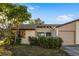 Tan house with brown roof, landscaping, and a garage at 1098 Soria Ave, Orlando, FL 32807