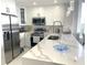 Modern kitchen featuring white cabinetry, stainless steel appliances, and a large quartz island at 13427 Blue Heron Beach Dr # 1001, Orlando, FL 32821