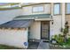 Tan colored townhouse exterior with a covered entryway and landscaping at 1350 Winter Green Way, Winter Garden, FL 34787